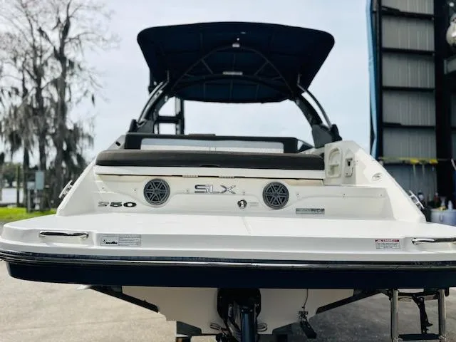Slide: The Image of 2016 Sea Ray 250 SLX boat, rear view with speakers and canopy, docked outdoors. - 9
