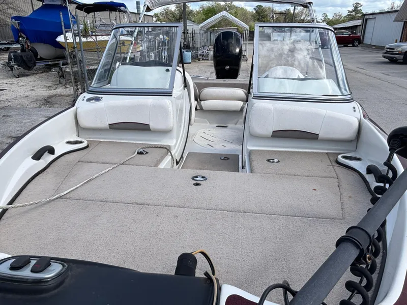 Slide: The Image of 2015 Nitro Z-7 Sport boat interior with seating and windshield, parked outdoors. - 14