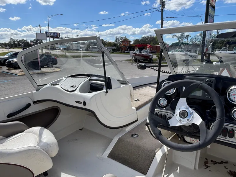 Slide: The Image of 2015 Nitro Z-7 Sport boat interior with steering wheel and dashboard, parked outdoors. - 17