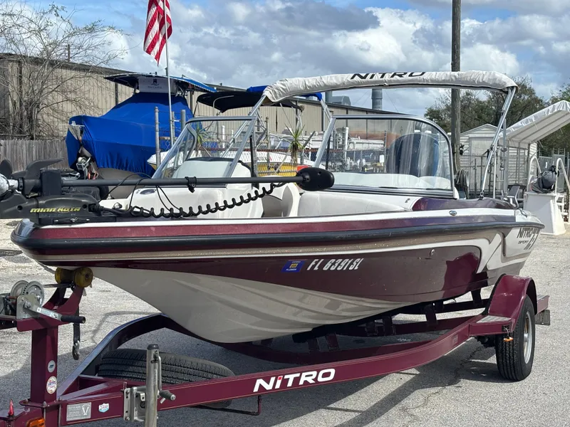 Slide: The Image of 2015 Nitro Z-7 Sport boat on trailer, parked outdoors with American flag in background. - 2