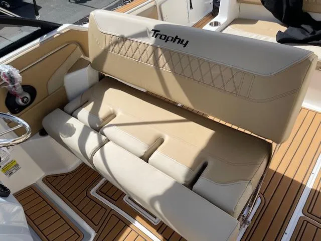 Slide: The Image of Bayliner TROPHY 22 SC 2025 boat interior with beige seating and wood-patterned flooring. - 18