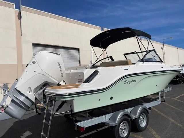 Slide: The Image of 2025 Bayliner TROPHY 22 SC boat on trailer, featuring a Mercury outboard motor. - 2