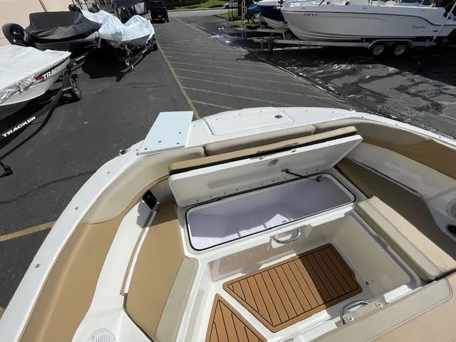 Slide: The Image of 2025 Bayliner TROPHY 22 SC boat with open storage compartment, docked outdoors. - 21