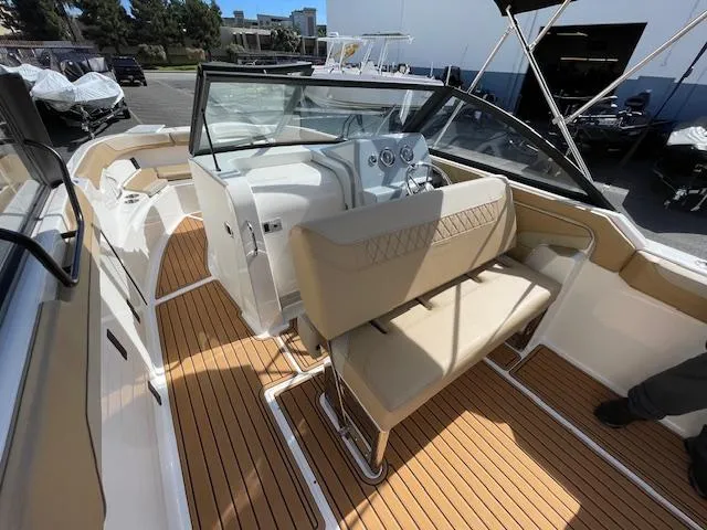 Slide: The Image of 2025 Bayliner TROPHY 22 SC boat interior with beige seating and wood flooring. - 34