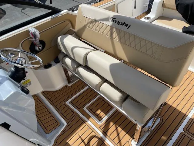 Slide: The Image of 2025 Bayliner TROPHY 22 SC boat interior with beige seating and wood-patterned flooring. - 36