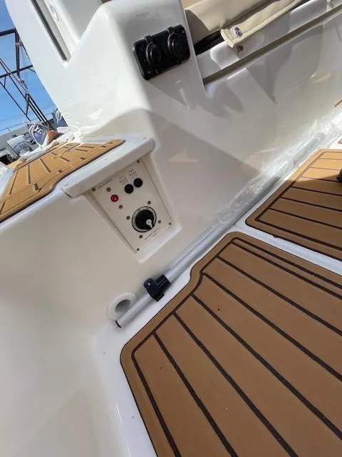 Slide: The Image of 2025 Bayliner TROPHY 22 SC boat interior with wood-style flooring and control panel. - 48