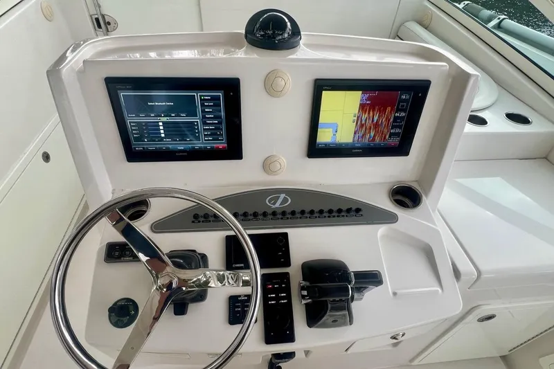 Slide: The Image of Control panel of a 2016 Jupiter 34 LX boat with dual screens and steering wheel. - 11