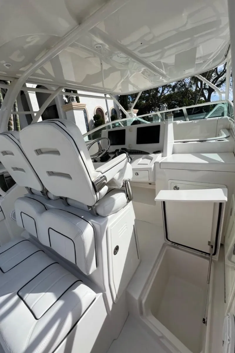 Slide: The Image of 2016 Jupiter 34 LX boat interior with white seating and modern dashboard. - 13