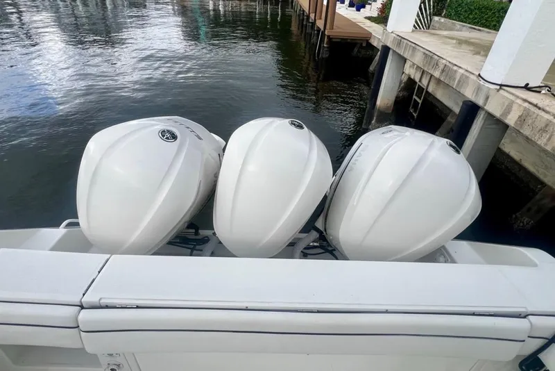 Slide: The Image of Three outboard motors on a 2016 Jupiter 34 LX boat docked by the water. - 16