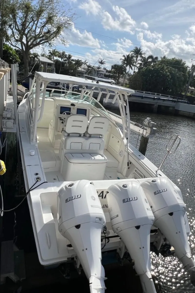 Slide: The Image of 2016 Jupiter 34 LX boat with triple engines docked by a scenic waterway. - 17