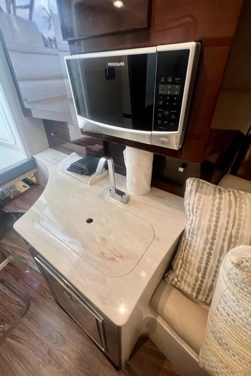 Slide: The Image of Interior of a 2016 Jupiter 34 LX featuring a modern kitchenette with a microwave. - 24