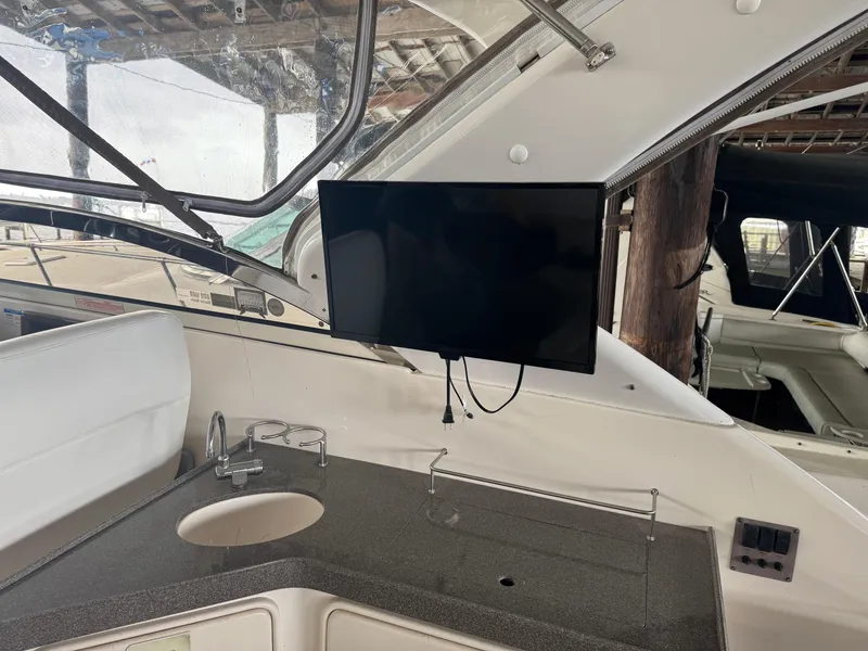 Slide: The Image of 2005 Regal 3560 Commodore boat interior with TV and kitchenette area. - 12