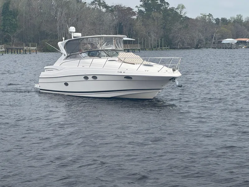 Slide: The Image of 2005 Regal 3560 Commandor boat docked on a lift by the waterfront. - 2