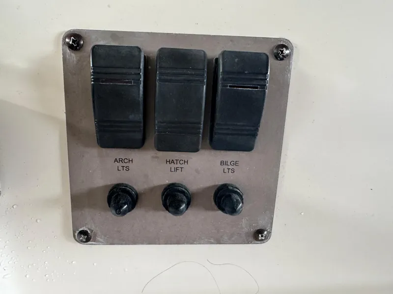 Slide: The Image of Control panel with switches for arch lights, hatch lift, and bilge lights on a 2005 Regal 3560 Commodore. - 22