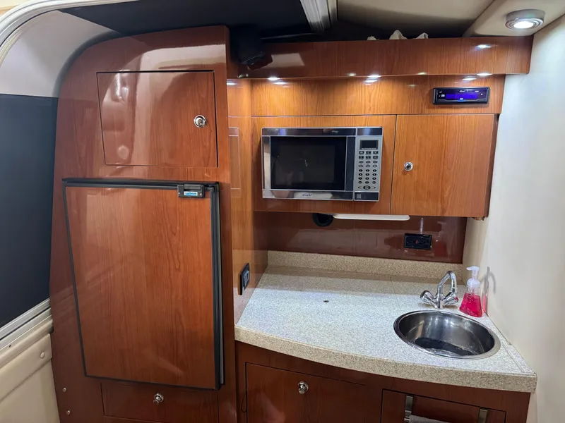 Slide: The Image of 2005 Regal 3560 Commodore yacht kitchen with microwave, sink, and wooden cabinetry. - 32