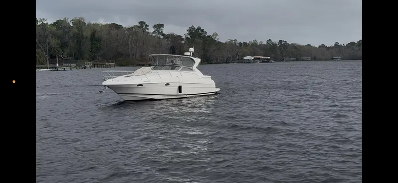 Slide: The Image of 2005 Regal 3560 Commodore yacht on a calm lake with trees in the background. - 4