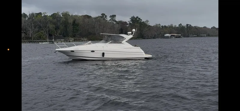 Slide: The Image of 2005 Regal 3560 Commodore yacht on calm water, surrounded by trees. - 5