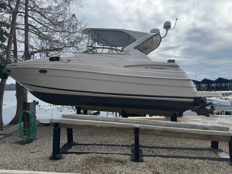 Slide: The Image of 2005 Regal 3560 Commodore boat docked on calm water, featuring a sleek design. - 7