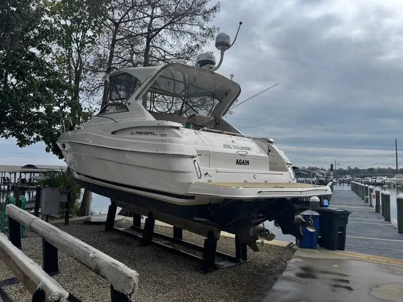 Slide: The Image of 2005 Regal 3560 Commodore yacht cruising on a calm lake with a forested shoreline. - 8