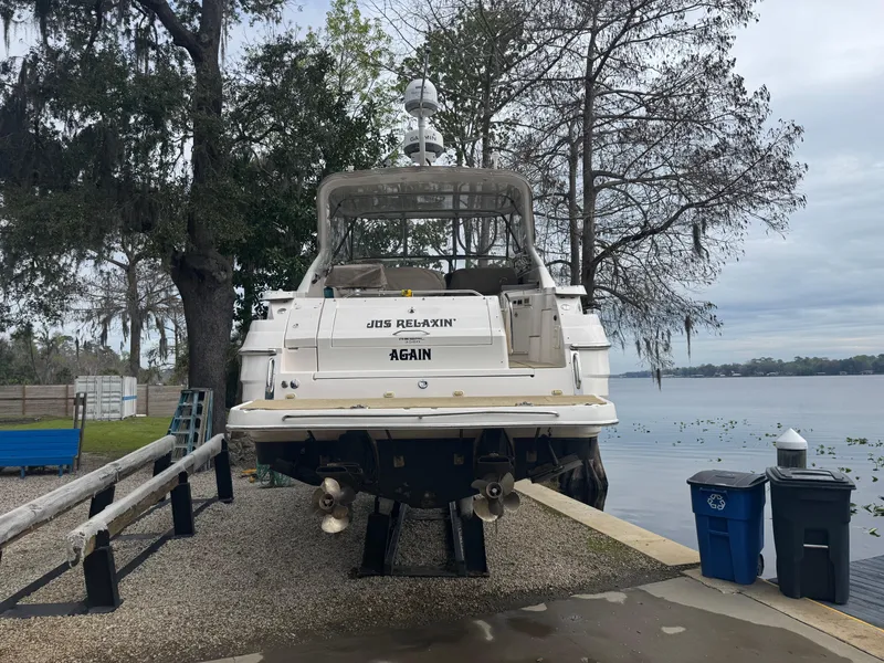 Slide: The Image of 2005 Regal 3560 Commodore yacht on a calm lake with forested shoreline. - 9