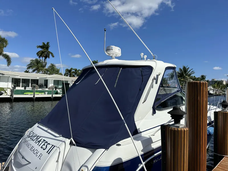 Slide: The Image of 2006 Formula 40 PC yacht docked, featuring a sleek design and blue canopy under a clear sky. - 10