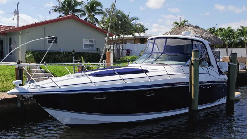 Slide: The Image of 2006 Formula 40 PC yacht docked by a waterfront home with palm trees. - 2