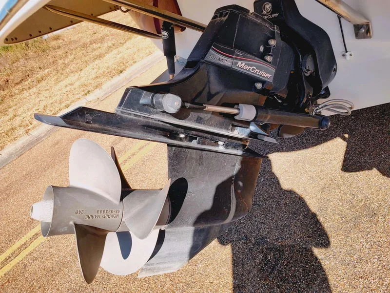 Slide: The Image of 2006 Crownline 270 BR boat with MerCruiser outdrive and propeller, parked on pavement. - 6