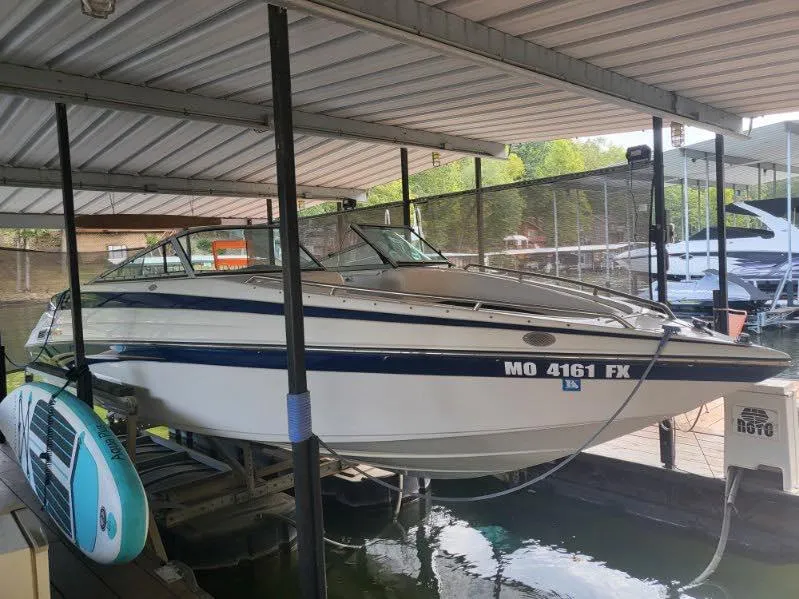 The Image of 2001 Crownline 248 BR boat docked under a covered marina. - 0