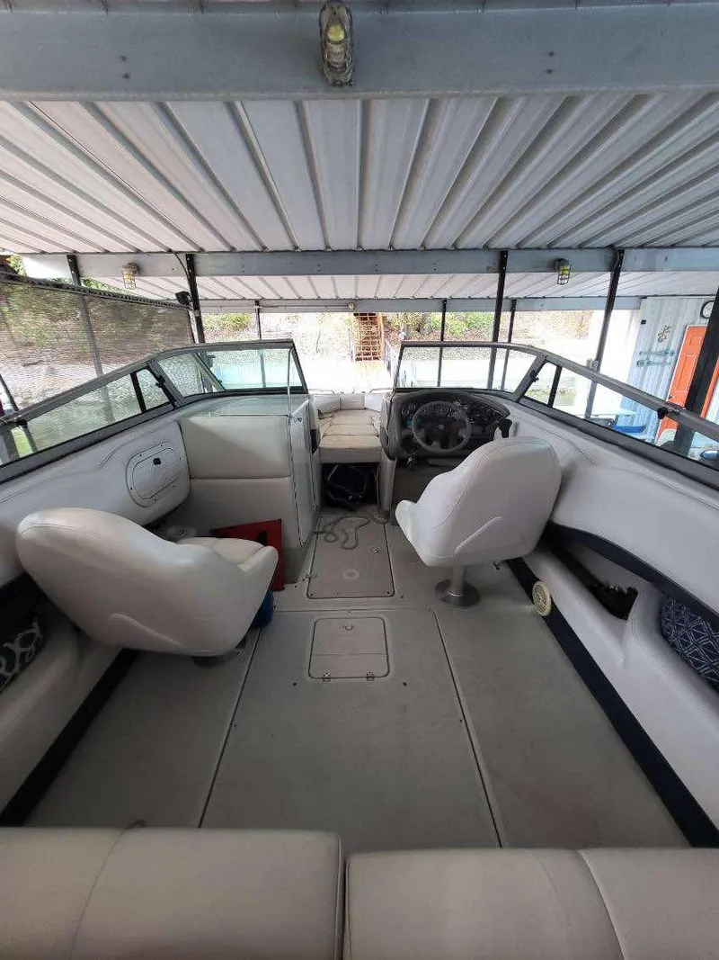 Slide: The Image of 2001 Crownline 248 BR boat interior with white seating and steering wheel under a canopy. - 3