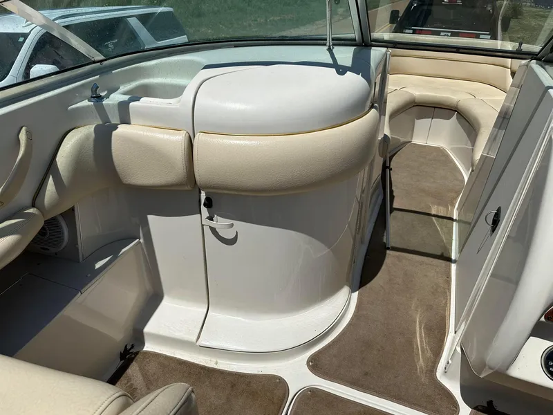 Slide: The Image of 2001 Sea Ray 260 Bow Rider interior with beige seating and carpeted flooring. - 7