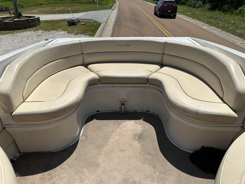 Slide: The Image of 2001 Sea Ray 260 Bow Rider boat with beige seating, parked on a road. - 9