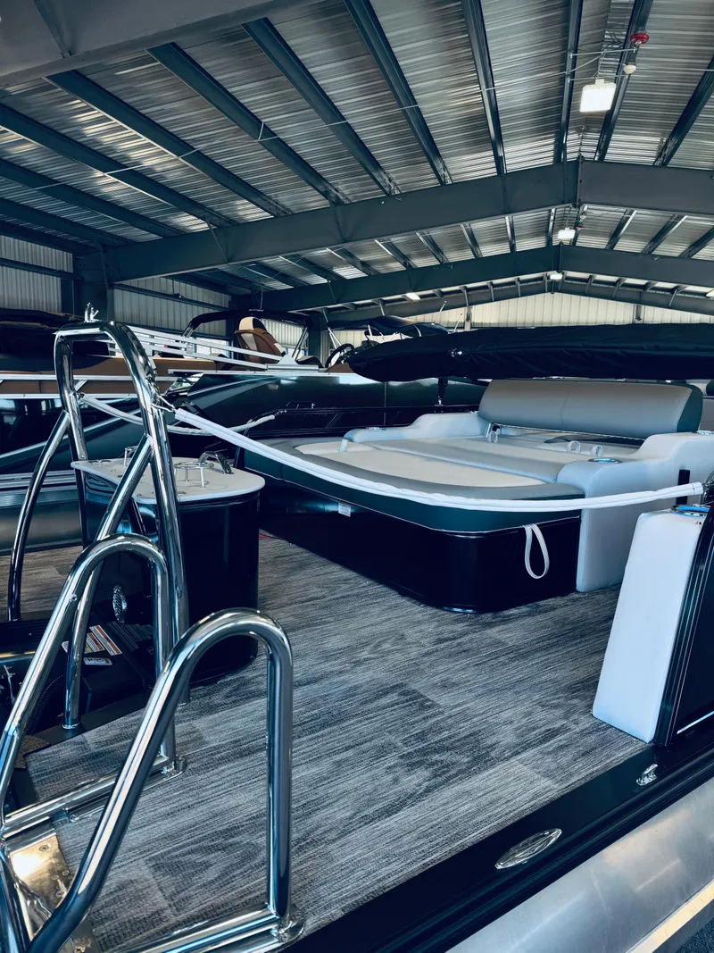 Slide: The Image of 2025 Tahoe Pontoon LTZ Versatile Rear Bench in a showroom, showcasing sleek design and luxury features. - 13