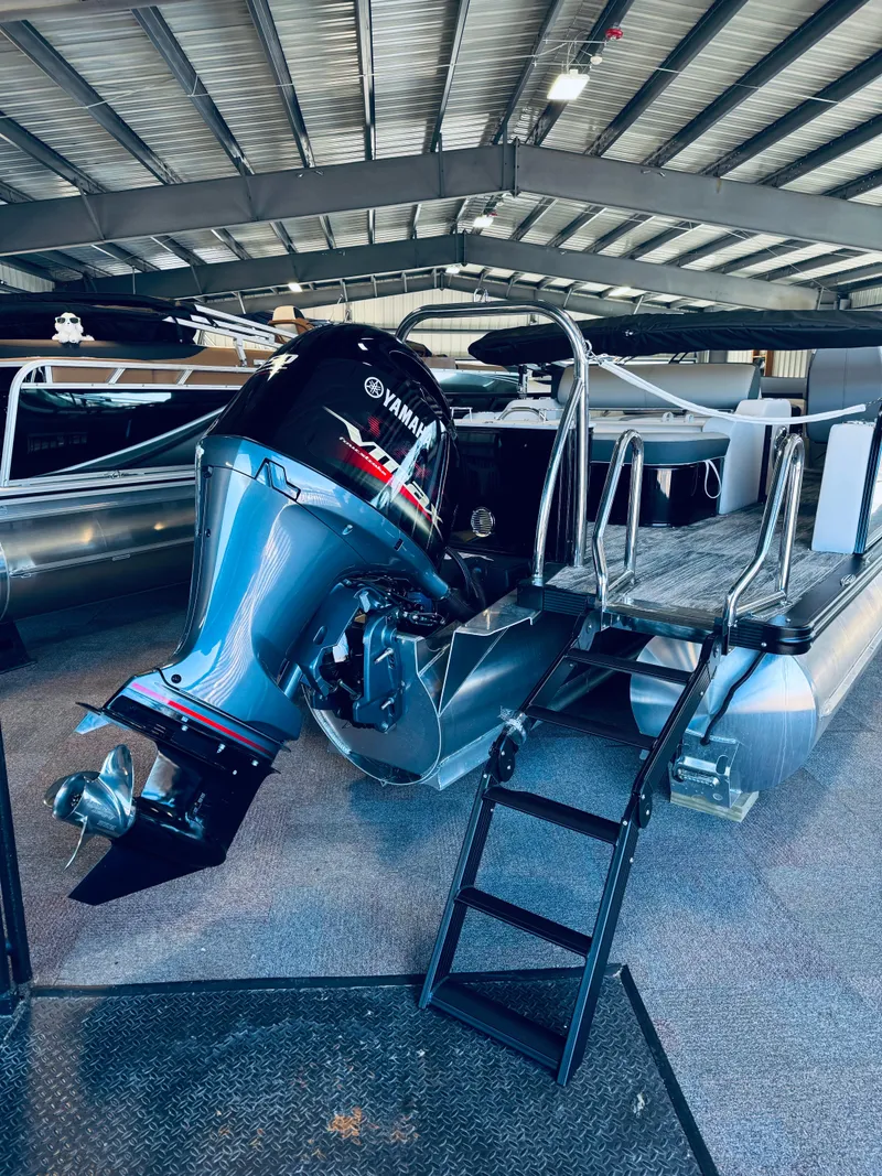 Slide: The Image of 2025 Tahoe Pontoon LTZ Versatile Rear Bench with Yamaha outboard motor in a showroom. - 16