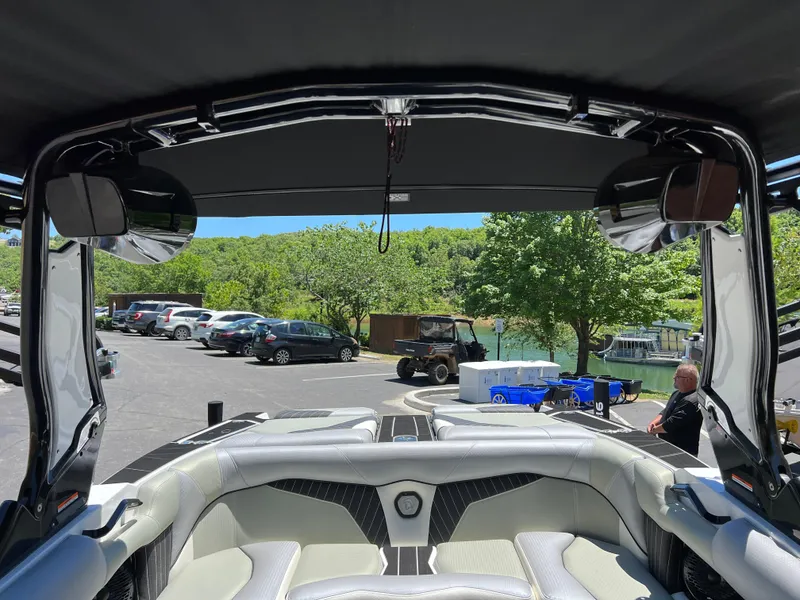 Slide: The Image of 2024 Centurion Fi23 boat interior with lake view and parked cars in background. - 12
