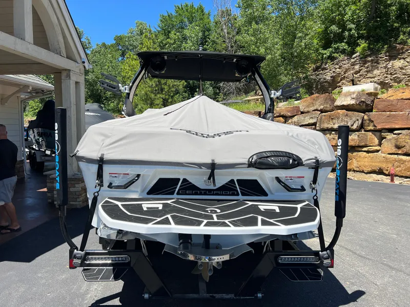 Slide: The Image of 2024 Centurion Fi23 boat with cover, parked outdoors on a sunny day. - 21