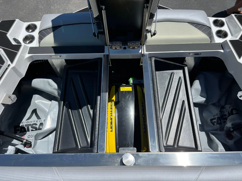Slide: The Image of 2024 Centurion Fi23 boat storage compartments with ballast bags and engine cover. - 8