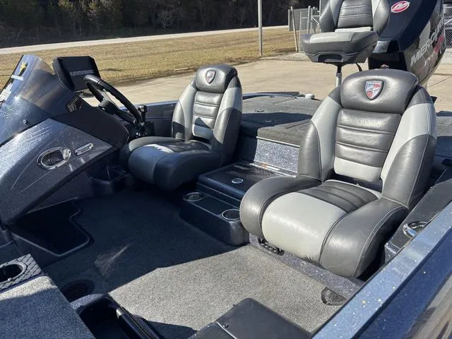 Slide: The Image of 2016 Triton 189 TRX boat interior with dual gray and black seats, steering console, and carpeted flooring. - 12