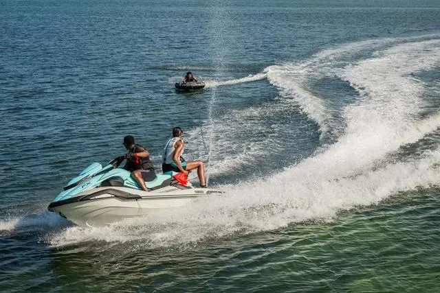 Slide: The Image of 2025 Yamaha Waverunner FX Cruiser HO speeding on open water with two riders. - 15
