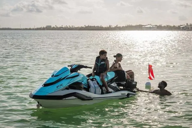 Slide: The Image of 2025 Yamaha Waverunner FX Cruiser HO on water with people enjoying a sunny day. - 16