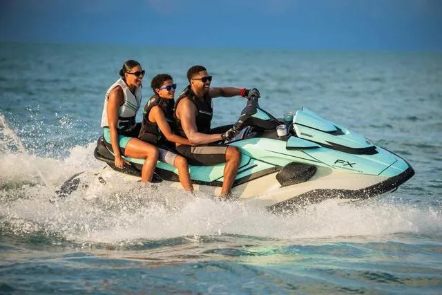 Slide: The Image of 2025 Yamaha Waverunner FX Cruiser HO with three riders enjoying a sunny day on the water. - 19