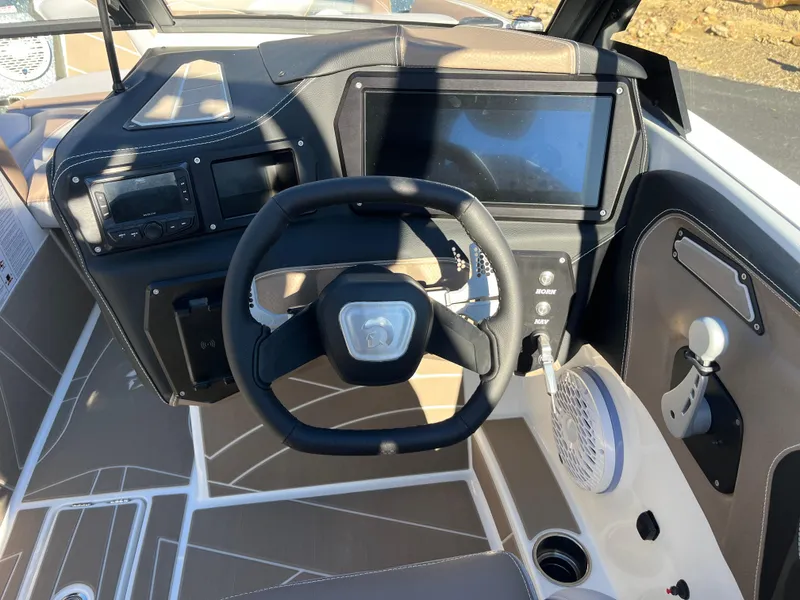 Slide: The Image of 2025 Centurion Fe25 boat dashboard with steering wheel and touchscreen display. - 17