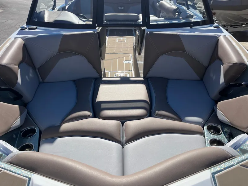 Slide: The Image of 2025 Centurion Fe25 boat interior with gray and brown seating, cup holders, and windshield. - 27