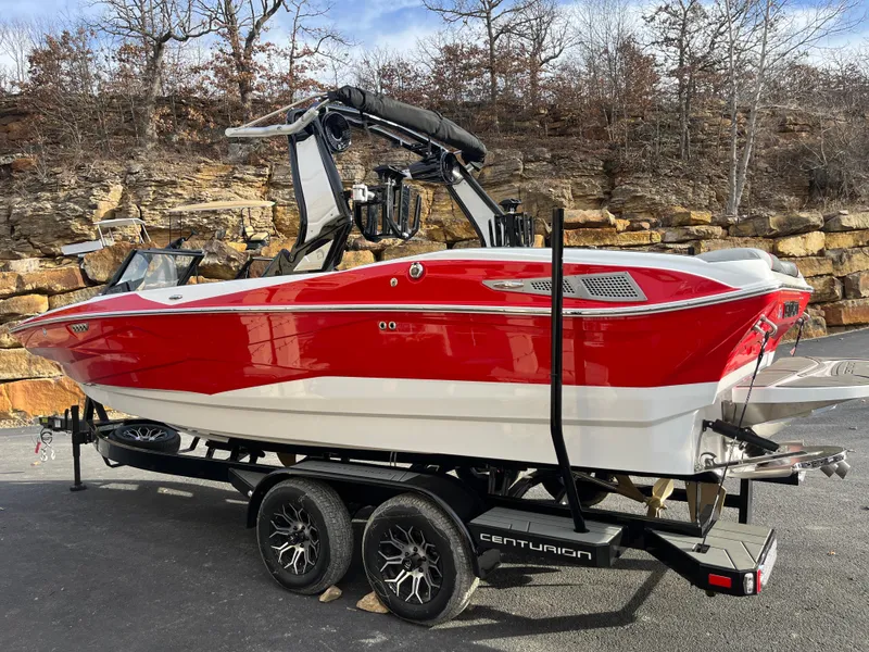 Slide: The Image of 2025 Centurion NV233 boat in vibrant red on a trailer, parked outdoors. - 10