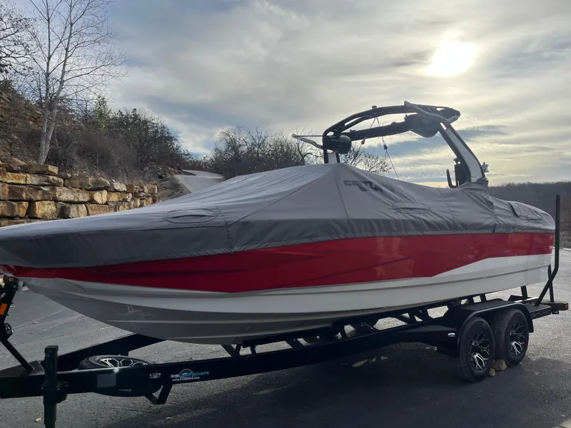 Slide: The Image of 2025 Centurion NV233 boat covered on a trailer, parked outdoors. - 13