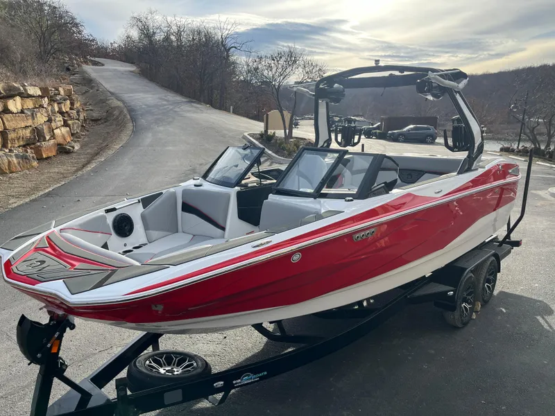 Slide: The Image of Red 2025 Centurion NV233 boat on trailer, parked on a scenic road. - 8