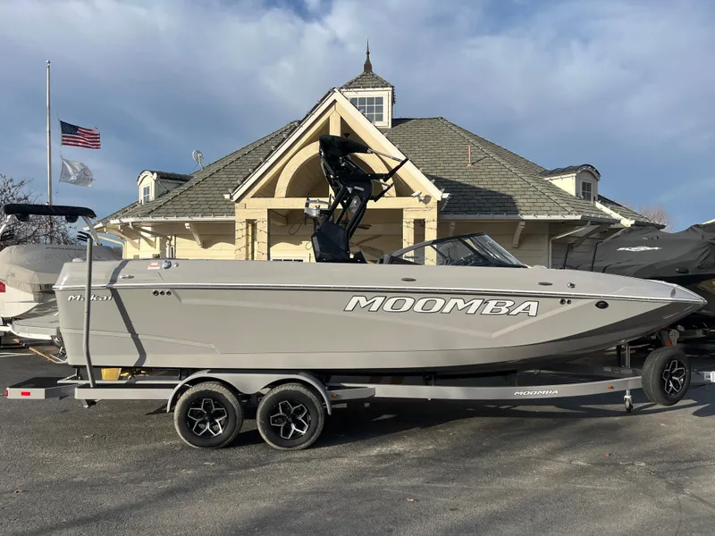 Slide: The Image of 2025 Moomba Makai boat on trailer, parked in front of a house with American flag. - 0