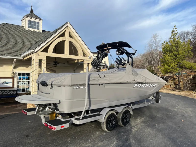 Slide: The Image of 2025 Moomba Makai boat on trailer, covered, parked near a house. - 12