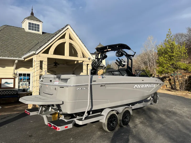 Slide: The Image of 2025 Moomba Makai boat on trailer near a house, ready for transport. - 2