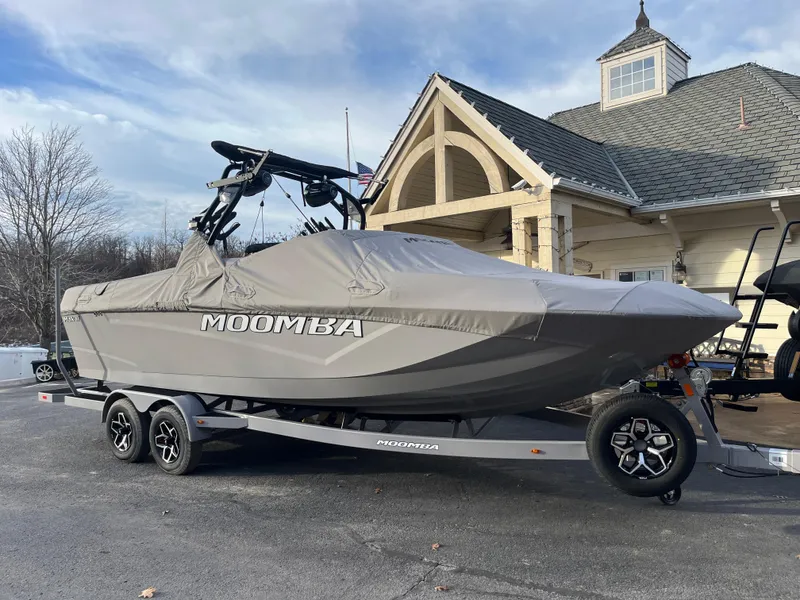 Slide: The Image of 2025 Moomba Makai boat covered on trailer, parked near a house. - 7