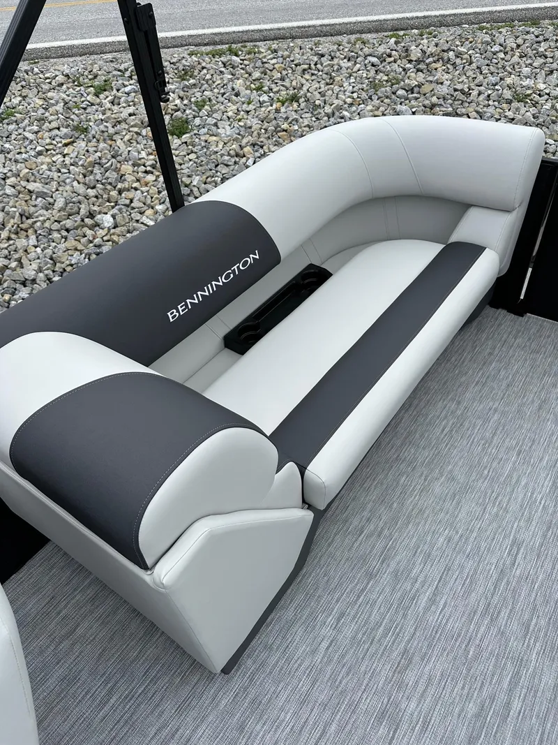 Slide: The Image of 2025 Bennington 22 SSR Quad Bench Tritoon interior seating, featuring sleek black and white upholstery. - 29